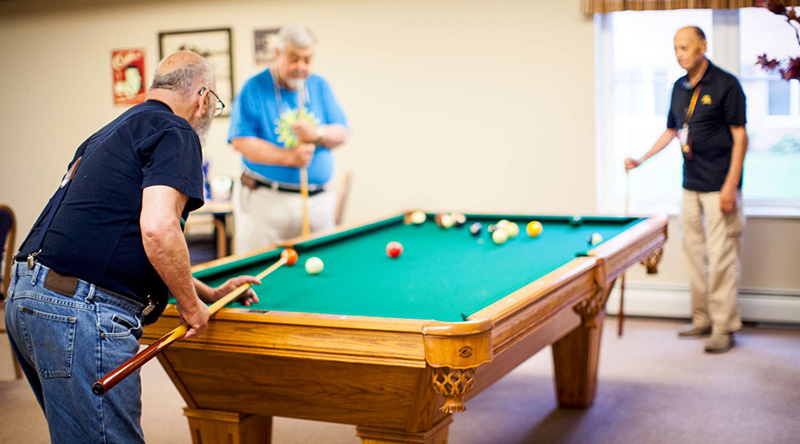 Residents playing pool in our long term care home 