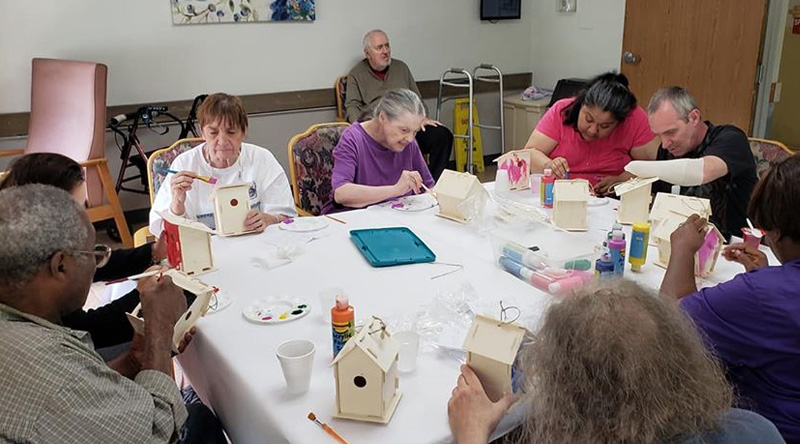 Enjoyable atmosphere as residents paint bird houses at our skilled care facility